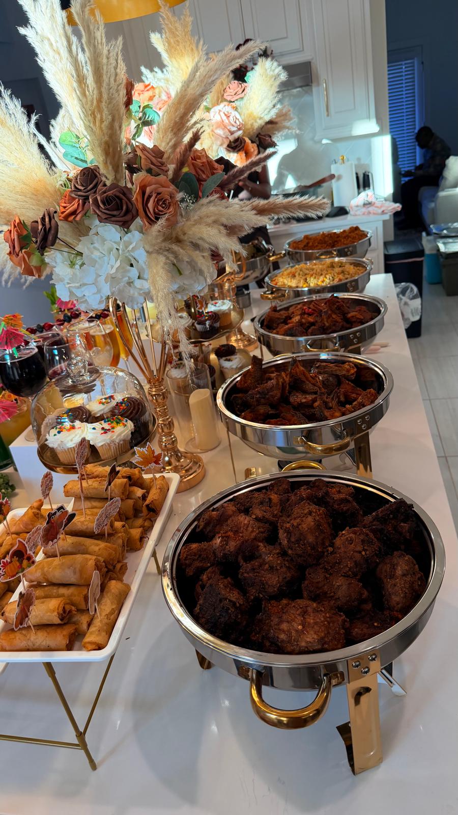 Catered buffet line with chafing dishes of Nigerian party food